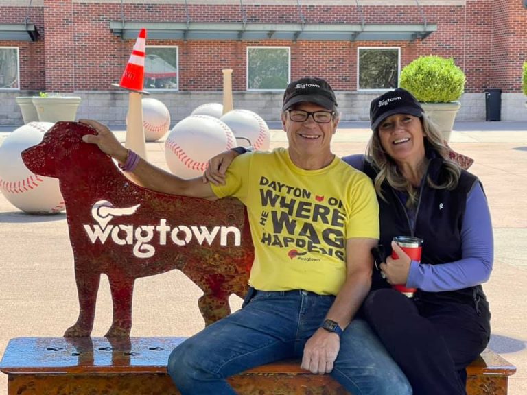 man and woman sitting with sign that says Wagtown