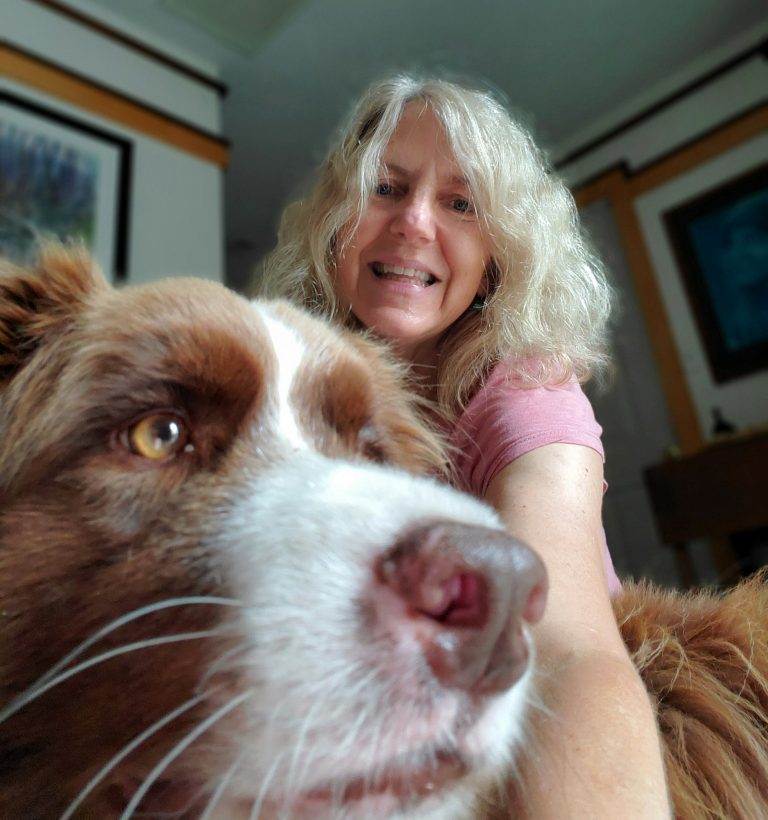 blonde woman behind red and white border collie